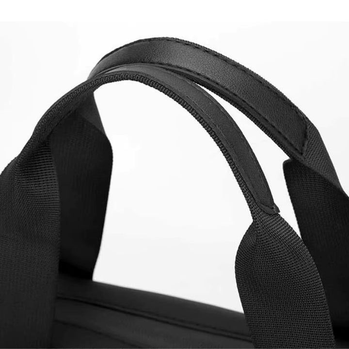 Détail des poignées renforcées du petit sac de voyage homme, couture solide pour un transport durable.