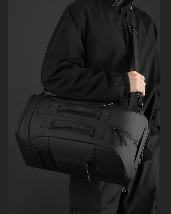 Sac à Dos de Voyage Bandoulière, noir porté sur l'épaule avec la bandoulière