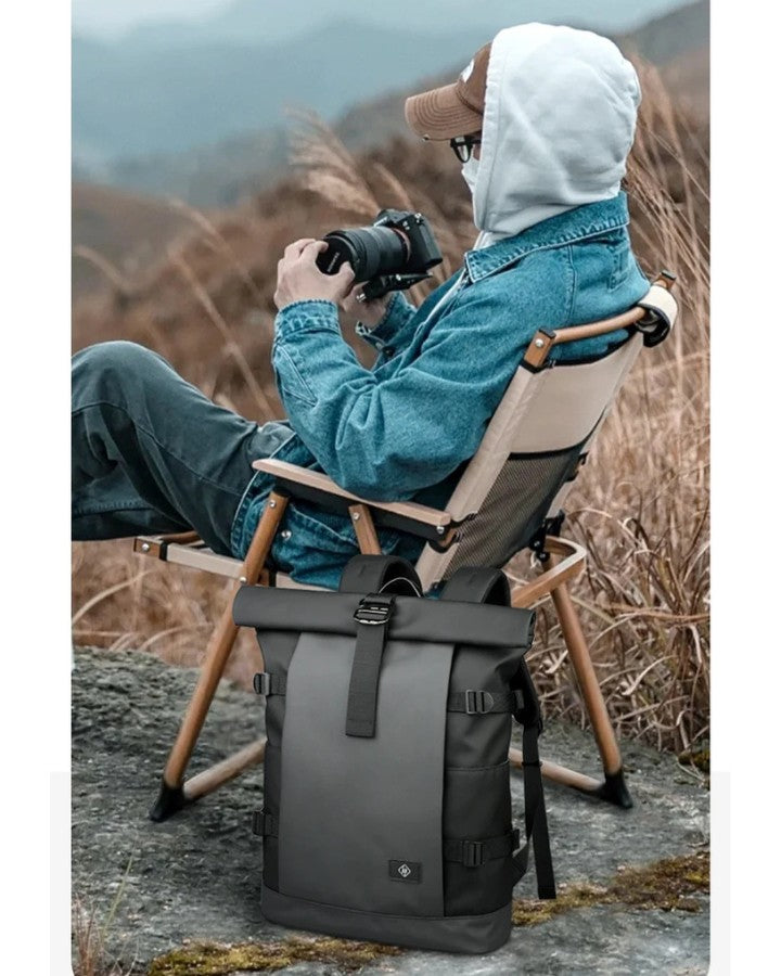 Sac à Dos avec Fermeture à Enroulement, photographe assis sur un siège en pleine nature