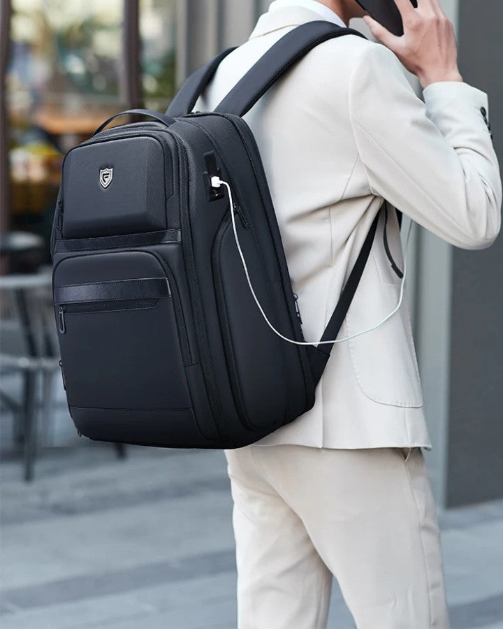 Sac à Dos de Voyage pour Ordinateur Portable, porté par un homme, téléphone en main, entrain de charger