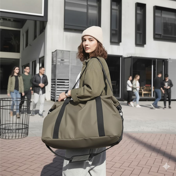 Femme portant un sac fourre tout de voyage kaki à l’épaule, parfait pour city trip et bagage cabine.