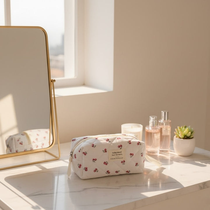 Petite trousse de toilette Cerise Today Mood posée sur coiffeuse lumineuse avec miroir