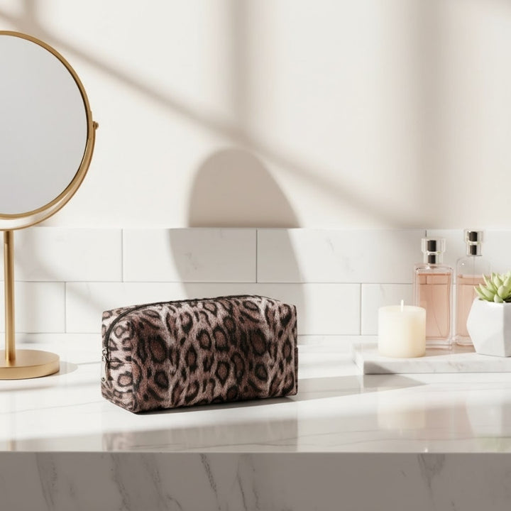 petite Trousse de toilette Léopard marron posée sur coiffeuse avec miroir et parfum