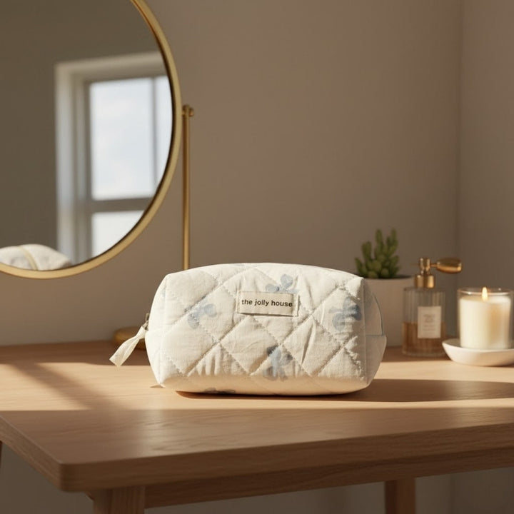 Petite trousse de toilette tissu matelassé nœuds bleus sur coiffeuse en bois