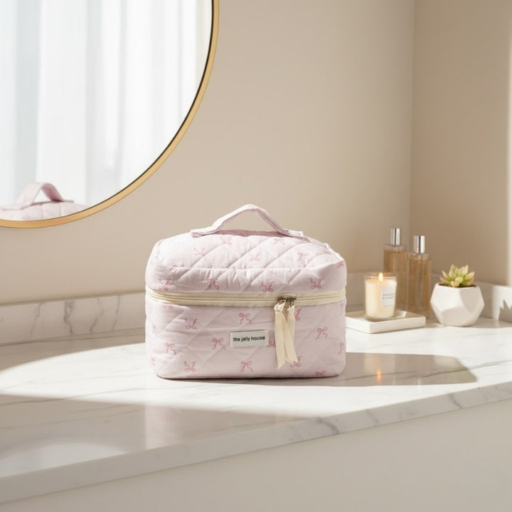 Vanity Rose Pâle de voyage sur plan de toilette, trousse cosmétique élégante